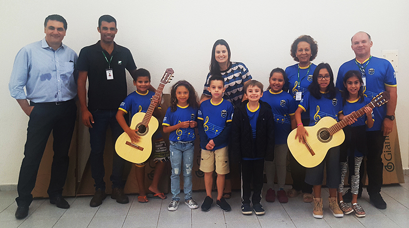 As crianas da aula de piano se encantaram com a visita e os novos violes que foram entregues por Abramides