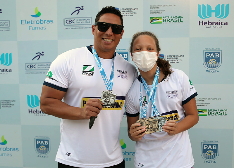 Atleta Maiah Nascimento exibe as 3 medalhas conquistadas, ao lado do tcnico talo Figueiredo